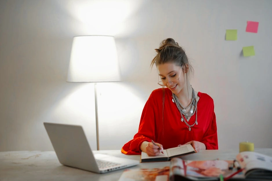 Osoba píšící si poznámky do zápisníku u stolu